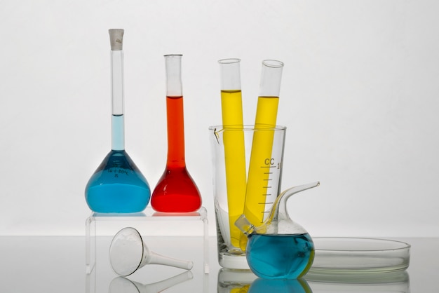 Verrerie de laboratoire avec liquides colorés et fond blanc