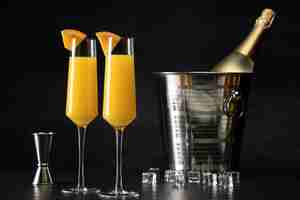 Photo gratuite verres à cocktail mimosa avec tranches d'orange