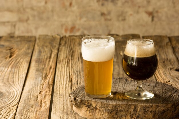 Verres de différents types de bière brune et légère sur table en bois