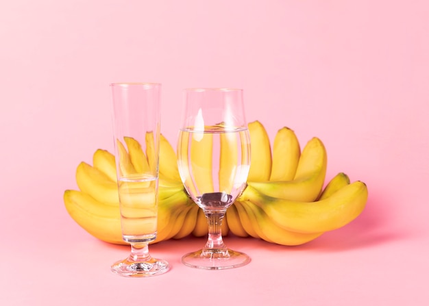 Verres d'eau et bouquet de bananes