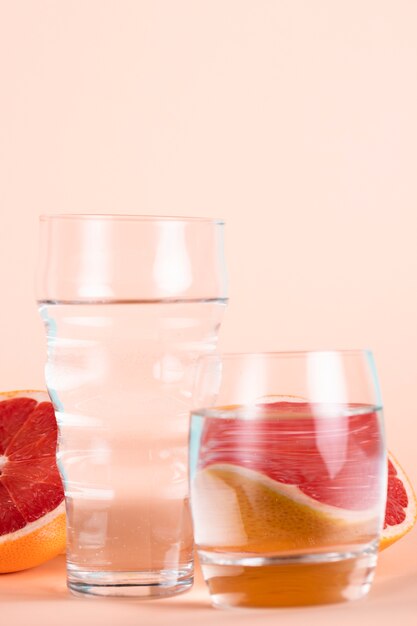 Verres d'eau avec des demi-oranges rouges