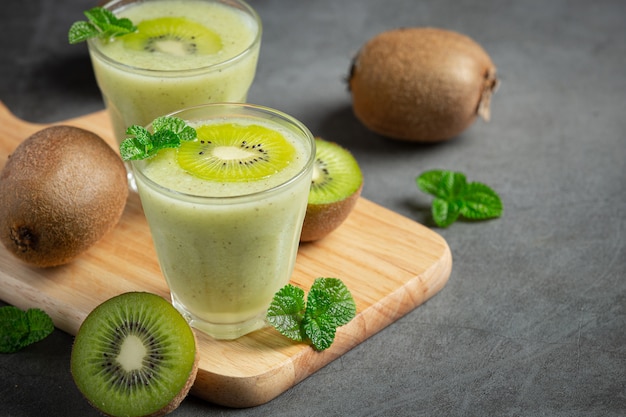 Verres de jus de kiwi mis sur une planche à découper en bois