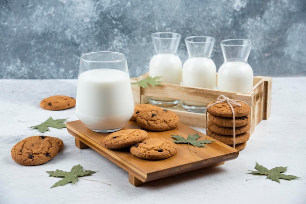 Verres de lait avec des biscuits au chocolat et des feuilles.