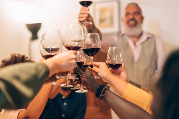 Verres trinquant au dîner - mains acclamant avec du vin