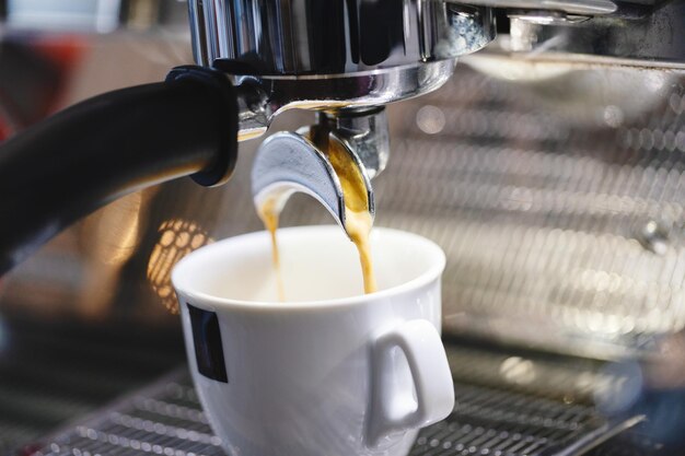 Verser l'espresso dans la tasse de la machine