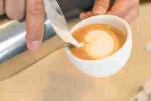 Photo gratuite verser le lait pour mélanger l'art latte coffee