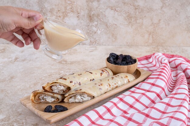 Verser à la main du lait concentré sur des crêpes maison.Photo de haute qualité