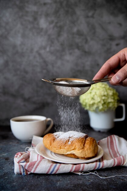 Verser le sucre sur le croissant vue de face