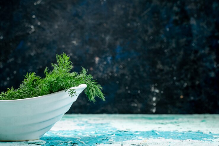 Photo gratuit verts frais à l'intérieur de la plaque sur un bureau bleu vif
