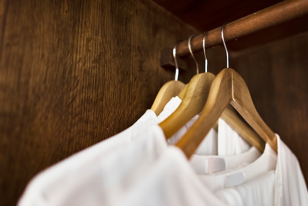 Photo gratuite vêtements blancs suspendus dans une armoire