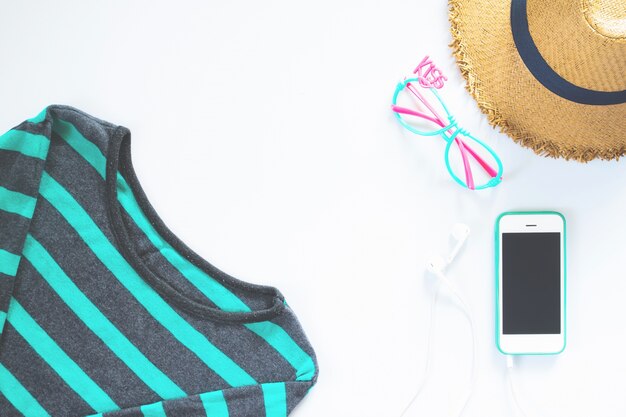 Des vêtements féminins et des collages d&#39;accessoires plats avec un t-shirt, des lunettes de mode, un chapeau avec un téléphone mobile et un écouteur sur fond blanc.