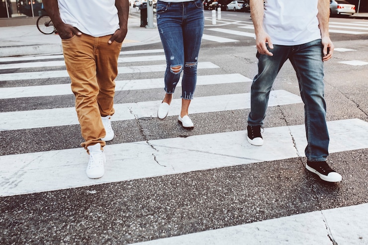 Photo gratuit vêtements de rue jeans hommes et femmes traversant la route en ville