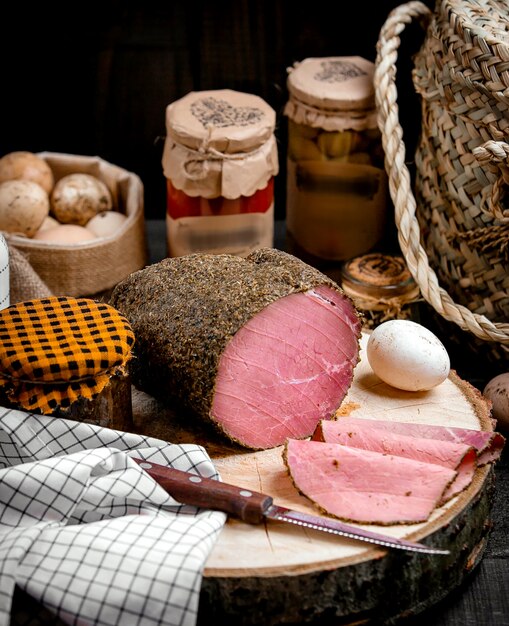 Viande d'agneau finement tranchée sur une mousse de bois