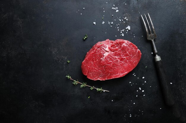 Viande crue aux épices et herbes sur table