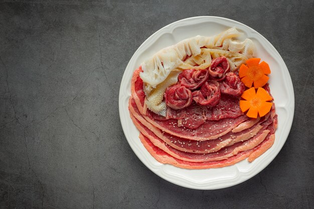 Viande crue dans une assiette blanche pour menu shabu hot pot