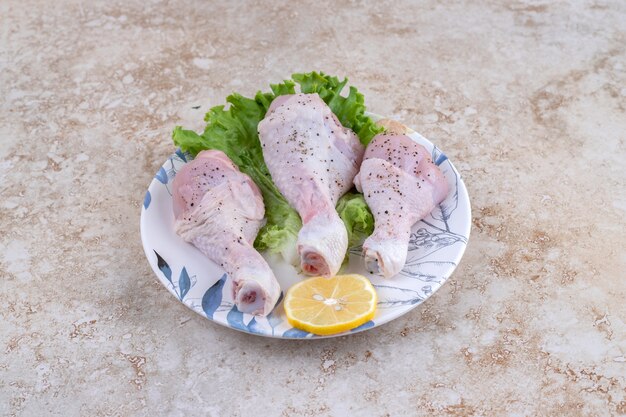 Viande de cuisses de poulet non cuites avec laitue et citron