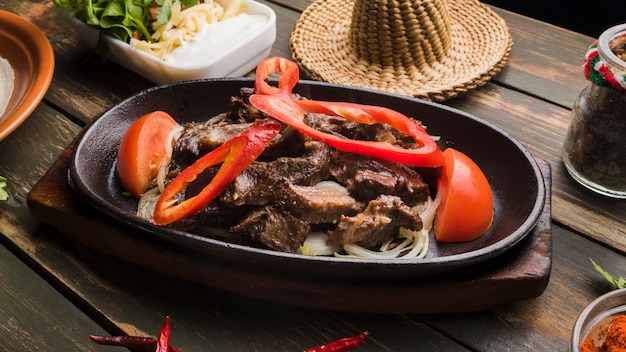 Viande cuite avec des légumes et différents apéritifs