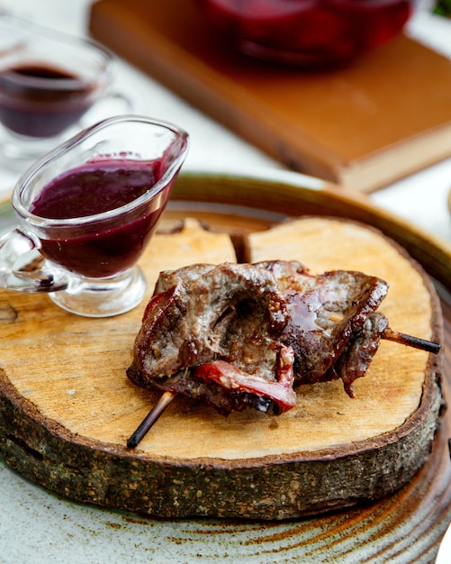 Viande frite sur une brochette avec sauce au cornouiller