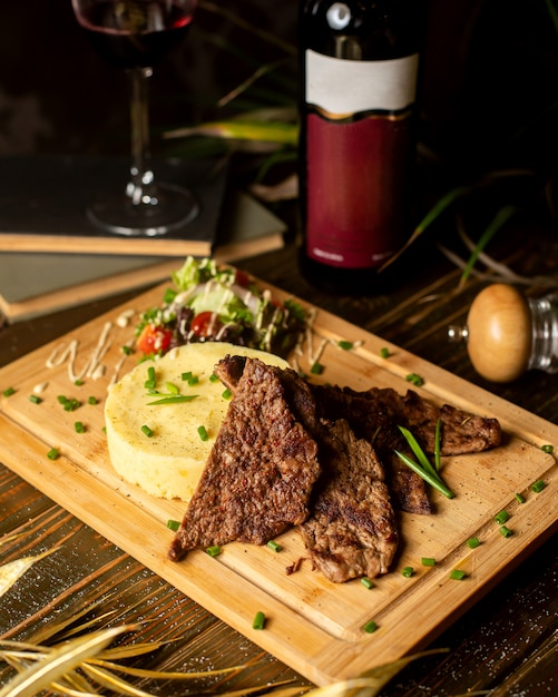 Viande frite servie avec purée de pommes de terre et salade