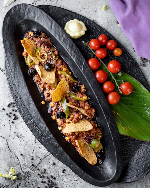 Viande hachée avec olive de maïs et poivre servie avec croustilles de tortilla