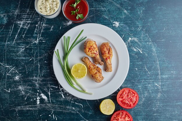 Viande de poulet épicée dans une assiette blanche avec des ingrédients autour.