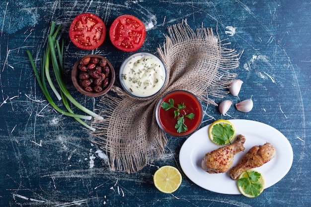 Viande de poulet épicée dans une assiette blanche avec des ingrédients autour.