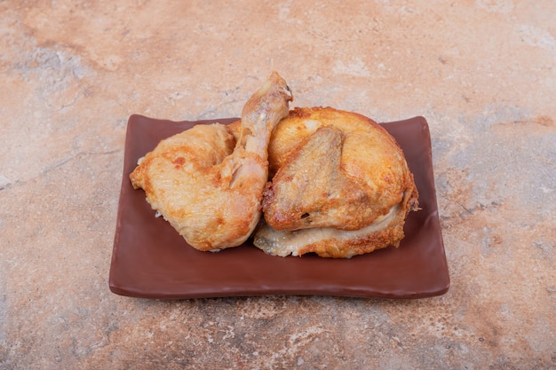 Viande de poulet frit dans un plateau de poterie