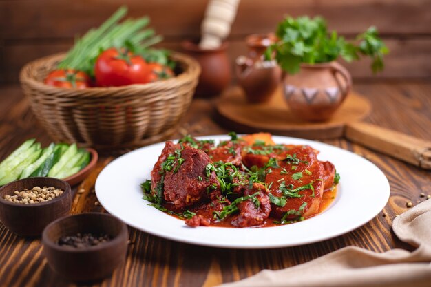 Viande en sauce tomate, pommes de terre, verts, concombre, vue latérale