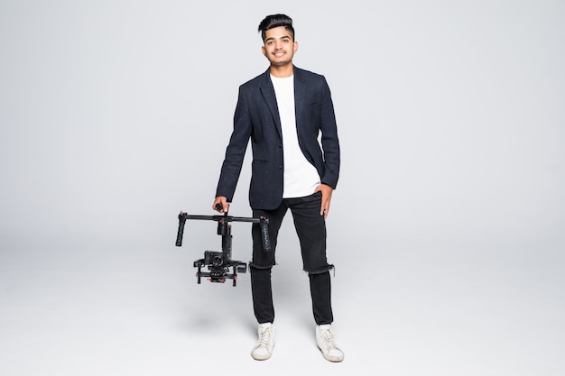 Vidéaste professionnel homme indien avec gimball vidéo slr ronin isolé sur fond de studio