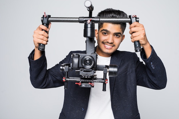 Vidéaste professionnel homme indien avec gimball vidéo slr ronin isolé sur fond de studio