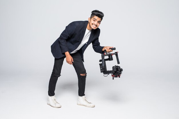 Vidéaste professionnel homme indien avec gimball vidéo slr ronin isolé sur fond de studio