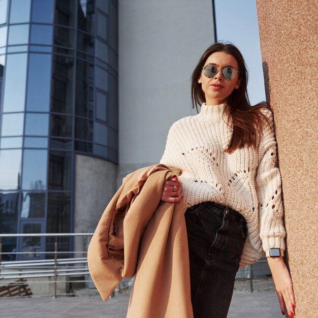 La vie en ville. Jeune belle fille dans des vêtements chauds se promène dans la ville à son heure du week-end