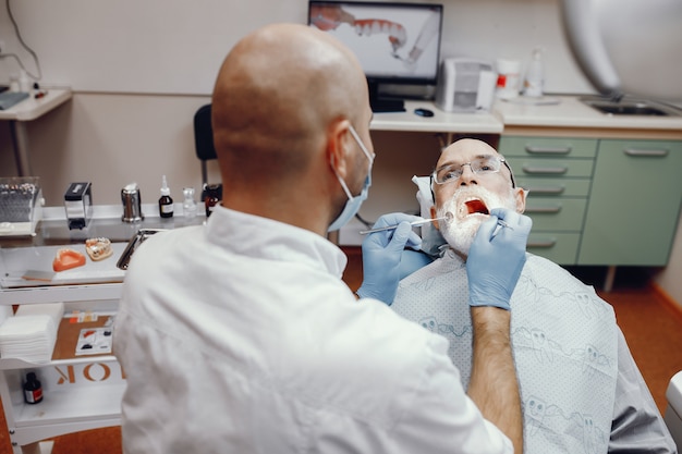 Vieil homme assis dans le bureau du dentiste