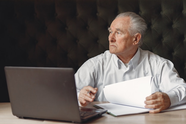 Vieil Homme Assis à La Table Et Travaillant Avec Un Ordinateur Portable