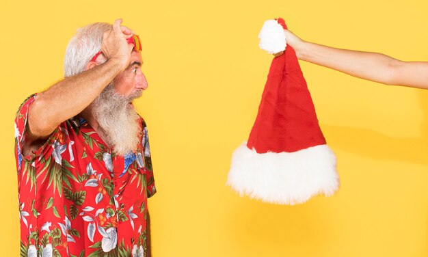 Vieil homme avec chemise tropicale et chapeau de Noël