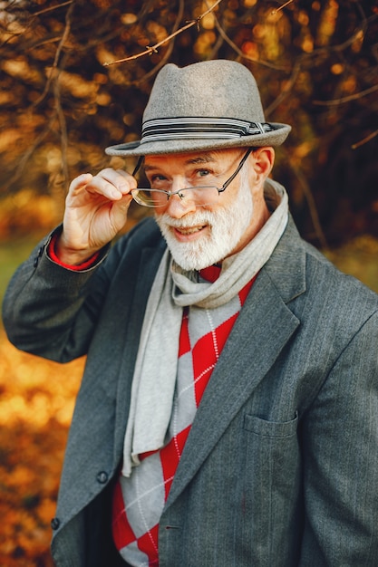 Vieil homme élégant dans un parc d&#39;automne ensoleillé