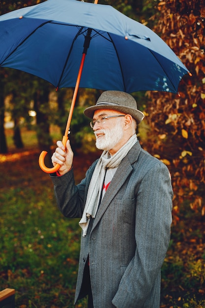 Vieil homme élégant dans un parc d&#39;automne ensoleillé