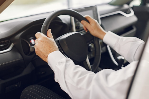 Vieil homme élégant dans un salon de voiture