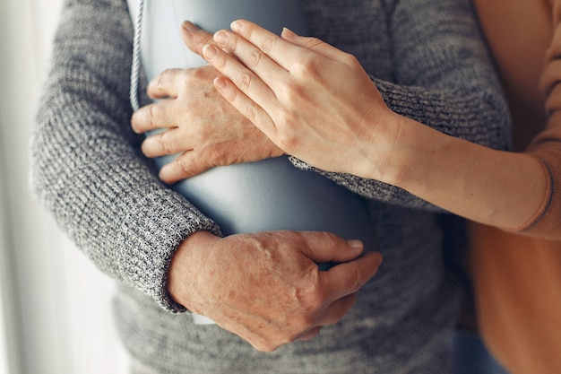 Vieil homme élégant debout à la maison avec sa petite-fille