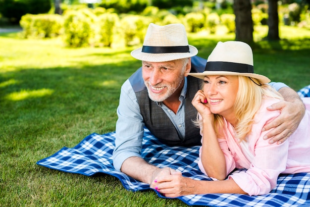 Vieil homme embrassant sa femme sur une couverture