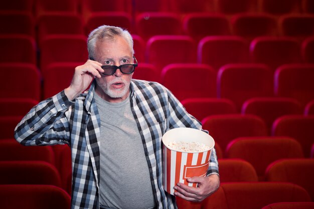 Vieil homme regardant un film au cinéma