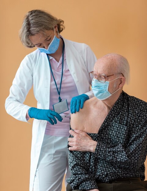 Un vieil homme de tir moyen se fait vacciner