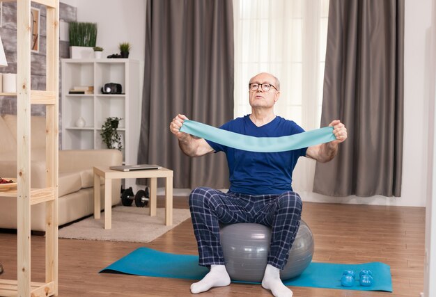 Vieil homme utilisant la bande de résistance pendant sa formation