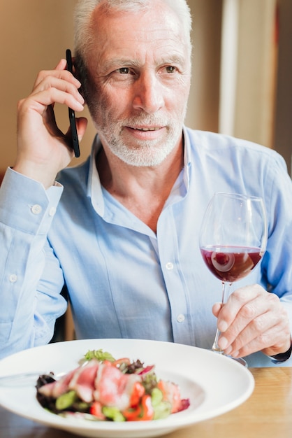 Vieil homme vue de face sur son téléphone