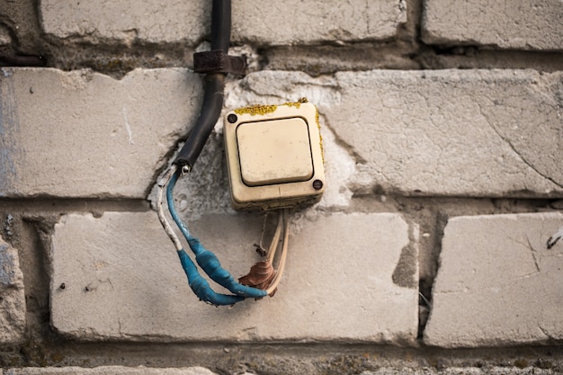 Photo gratuite le vieil interrupteur sur le mur de briques, tordait le ruban bleu.