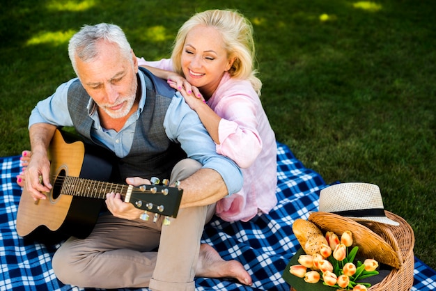 Vieille femme appréciant sa chanson de guitare homme