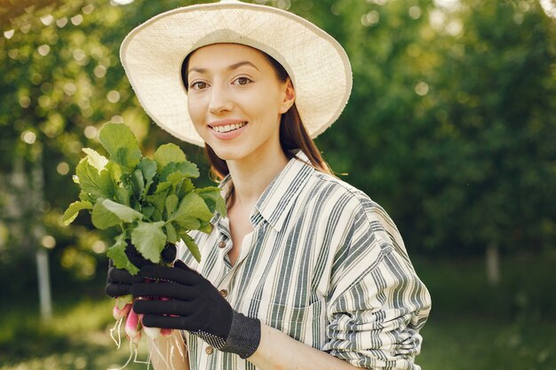 Vieille femme dans un chapeau tenant des radis frais
