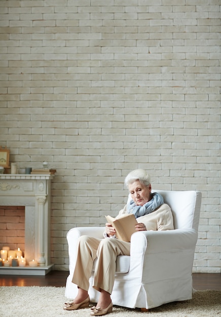 Photo gratuite vieille femme enveloppée dans la lecture