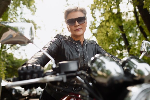 Vieille femme à faible angle avec une moto cool