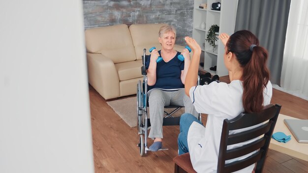 Vieille femme invalide en fauteuil roulant faisant une formation de réadaptation avec le soutien d'un médecin. Infirmière handicapée handicapée en convalescence aide professionnelle infirmière, traitement et réadaptation en maison de retraite médicalisée